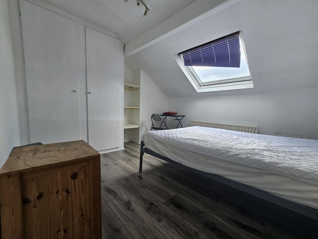 A well-lit, tidy single bedroom featuring a com...
