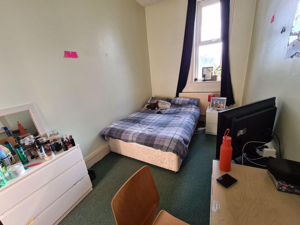 A cozy single bedroom with a bed positioned nea...