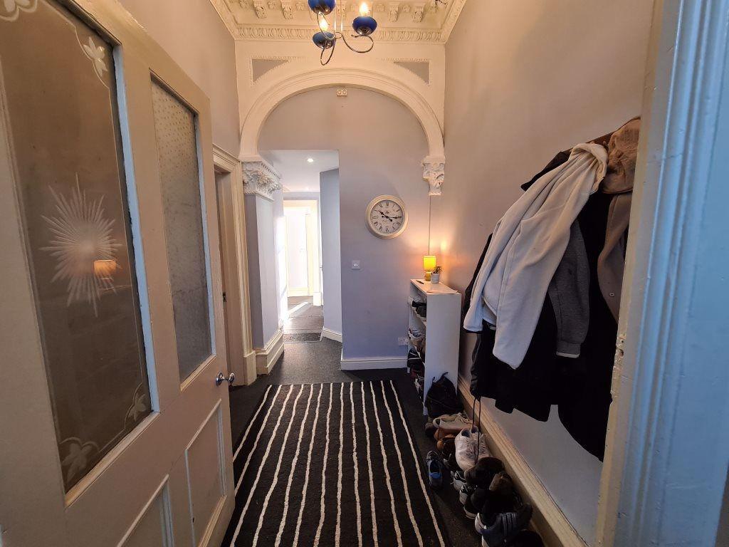 A well-lit, inviting hallway with a striped rug...