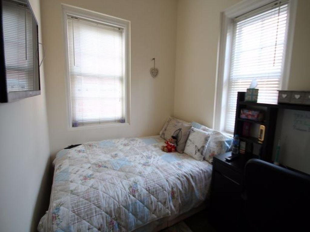 A cozy bedroom featuring two windows providing ...