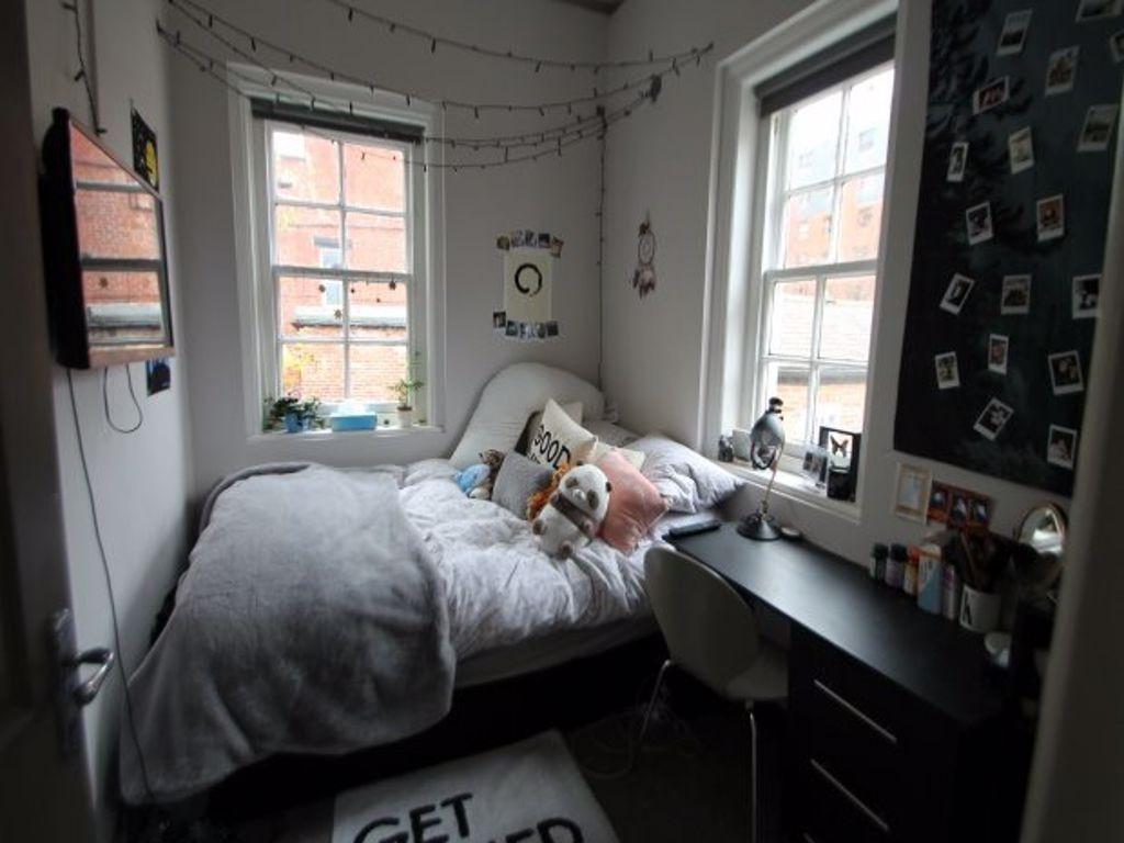 A cozy student bedroom featuring a single bed, ...