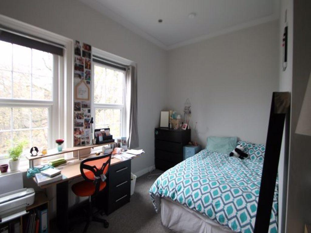 A cozy student bedroom featuring a comfortable ...