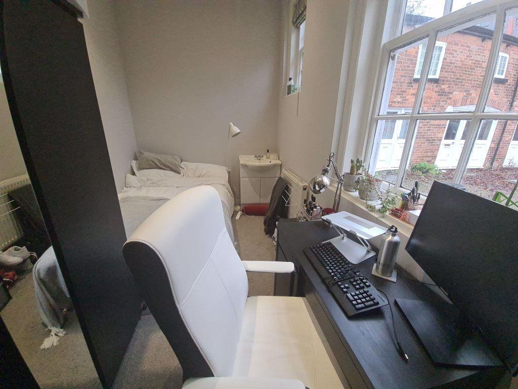 A well-lit study area featuring a comfortable c...