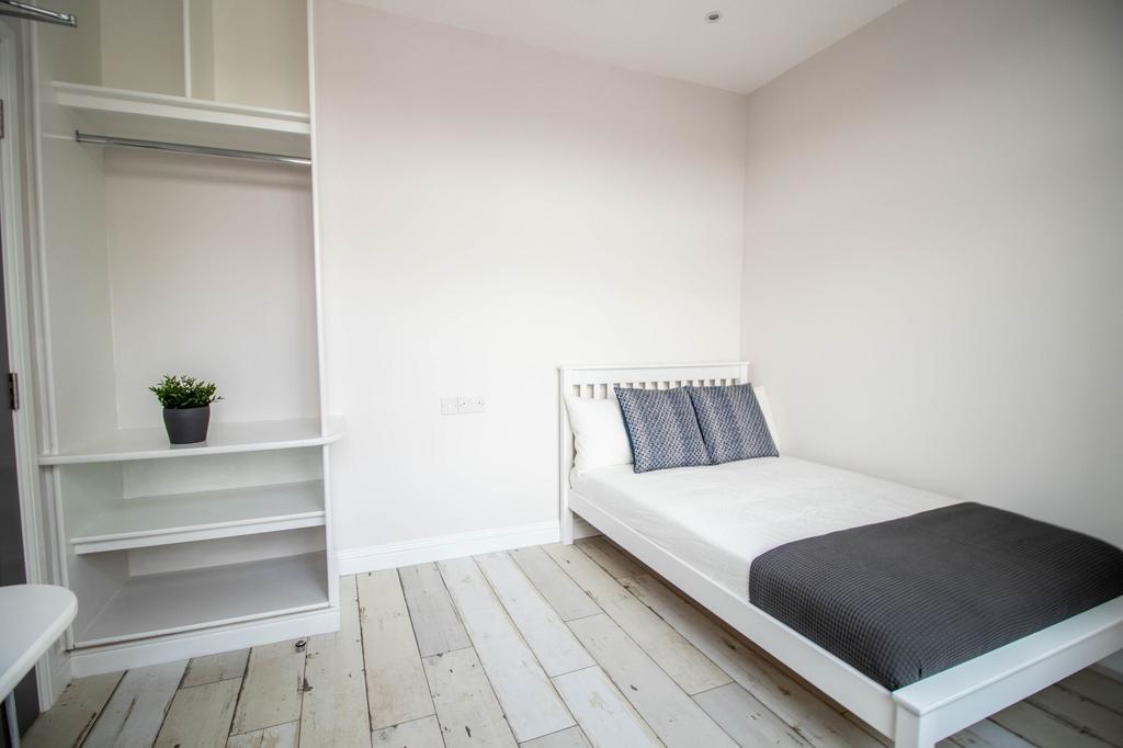 A bright and clean double bedroom featuring a w...