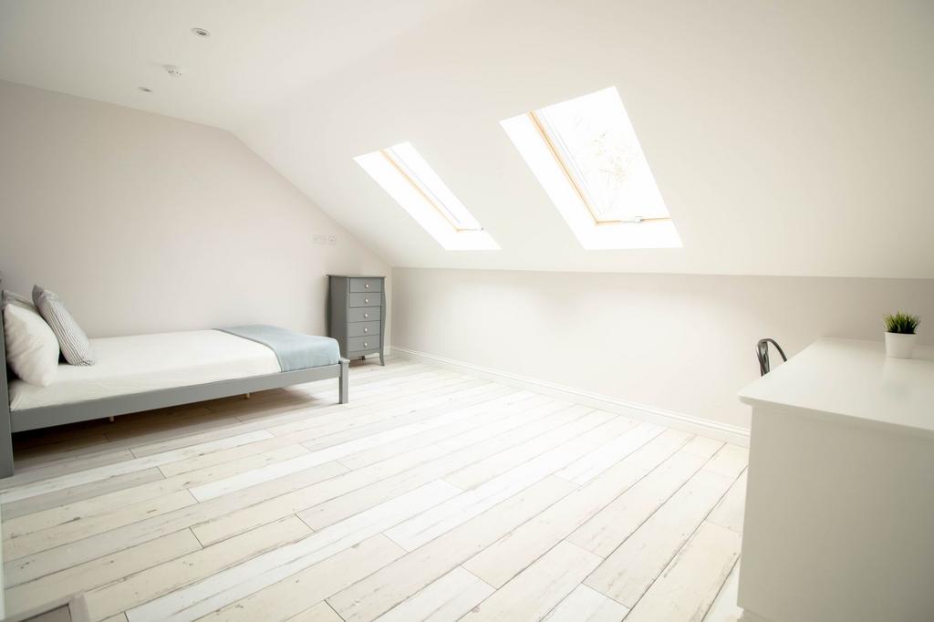 Bright and airy master bedroom featuring two la...