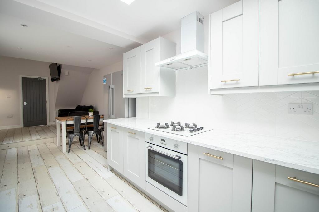 Bright and modern white kitchen with ample stor...