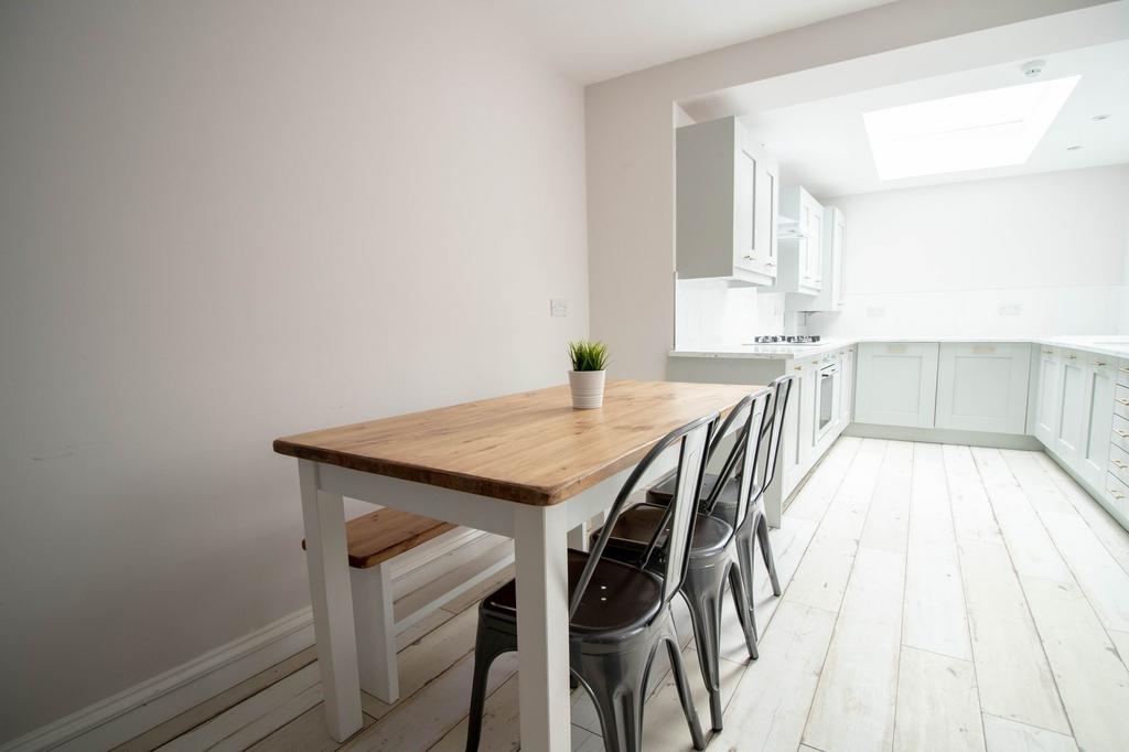 Bright and airy kitchen with sleek white cabine...