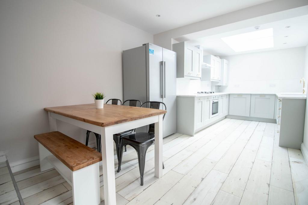 Bright and modern kitchen featuring white cabin...