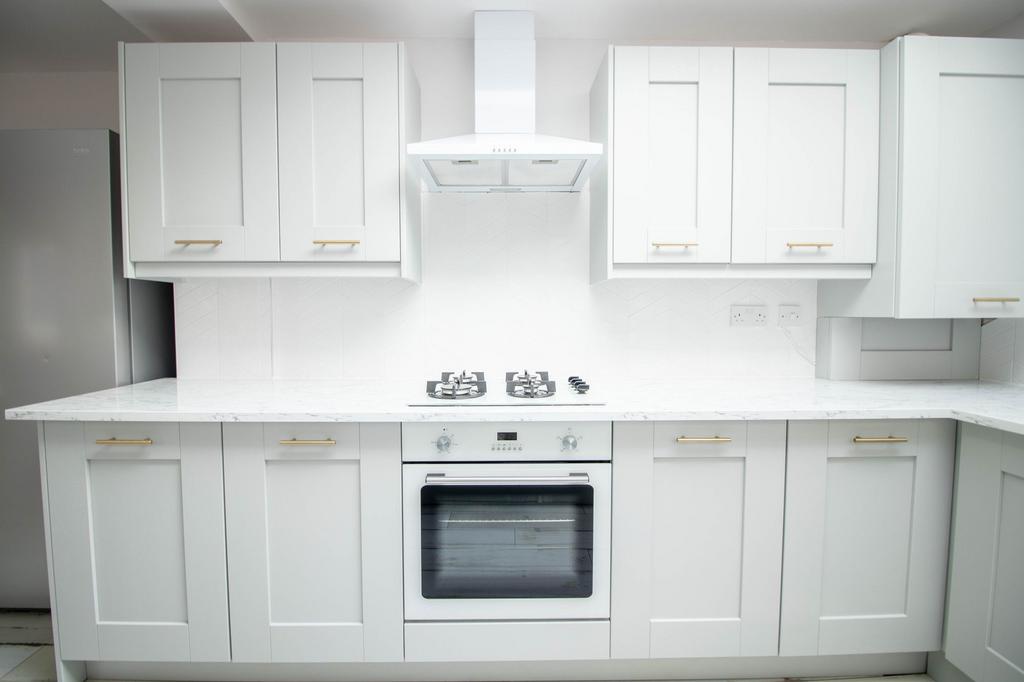 Bright and modern kitchen with clean white cabi...