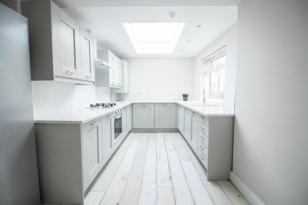 Bright and modern kitchen featuring sleek white...