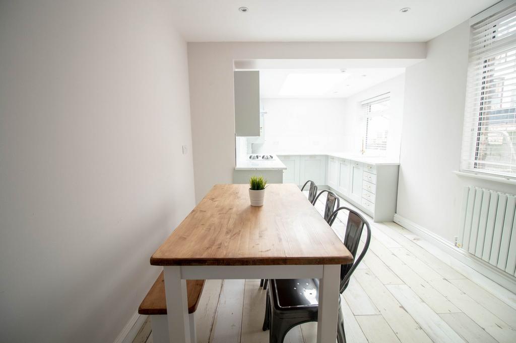 Bright, modern kitchen with white cabinetry and...
