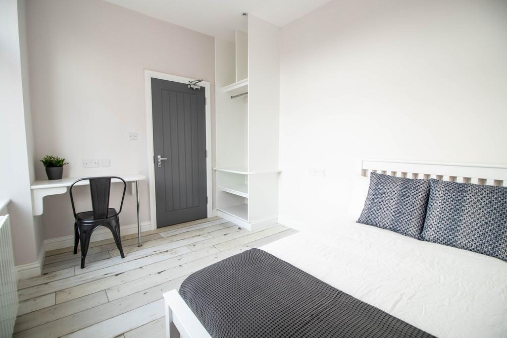 Bright and tidy master bedroom featuring a comf...