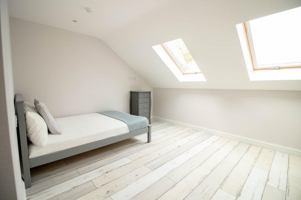 A bright and tidy bedroom with a simple, modern...