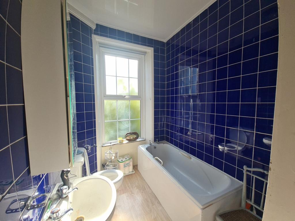 A clean, modern bathroom featuring a large bath...