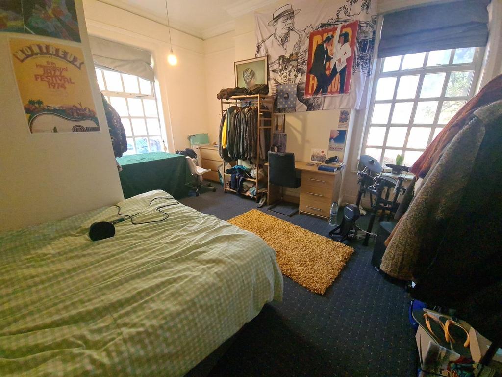 A cozy bedroom featuring a neatly made bed, two...