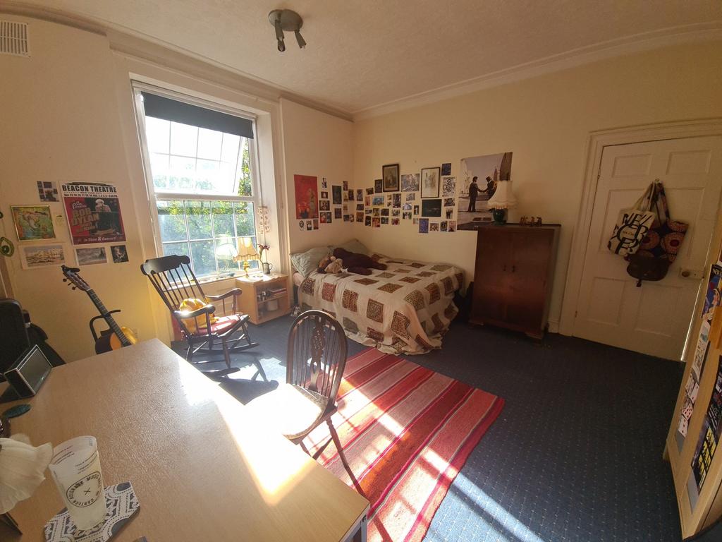 A cozy bedroom featuring a large window that al...