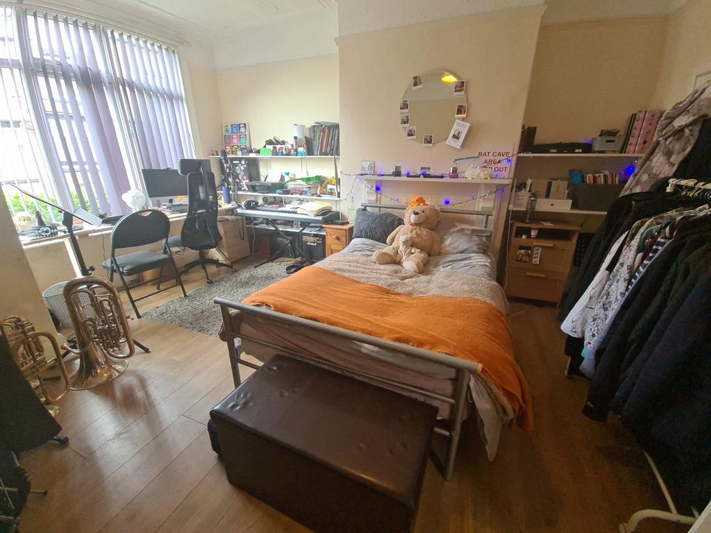 A cozy single bedroom featuring a comfortable b...