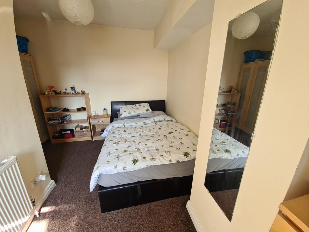 A well-lit double bedroom featuring a comfortab...