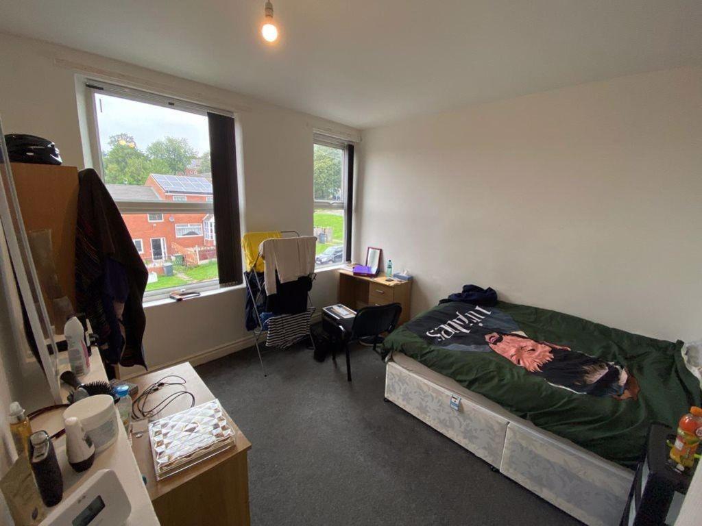 A cozy single bedroom featuring a bed with a co...