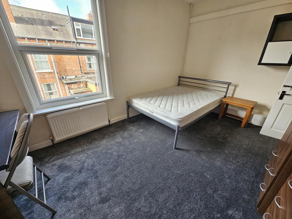 A bright, neatly maintained bedroom featuring a...