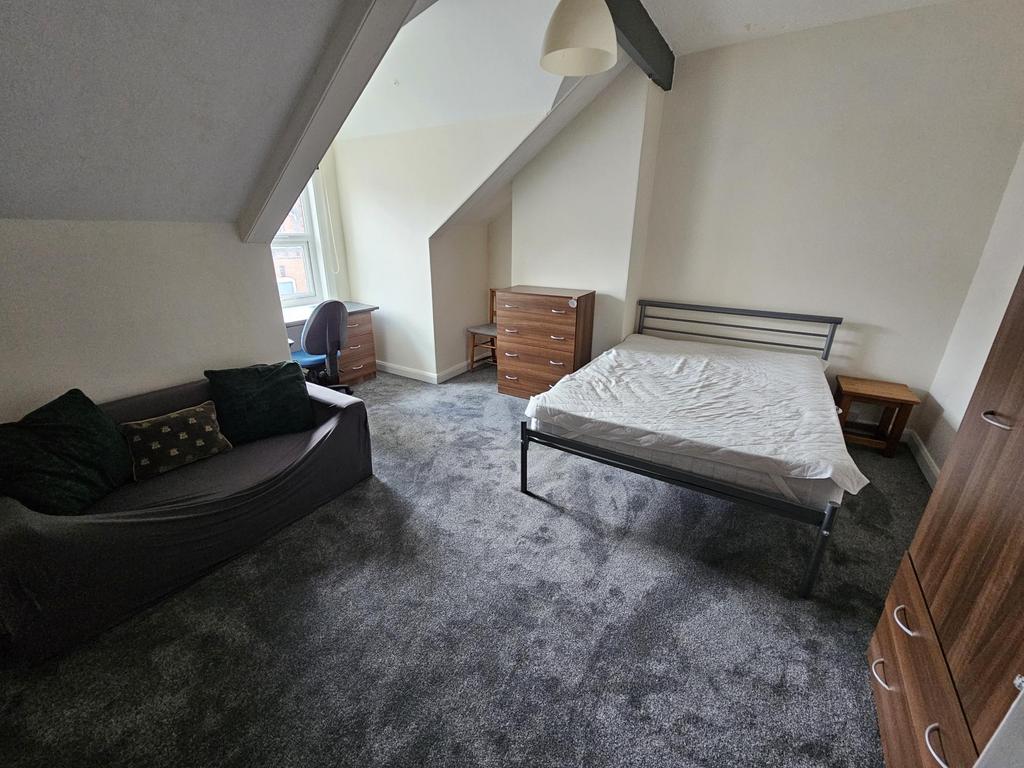 A cozy bedroom with a large window providing na...