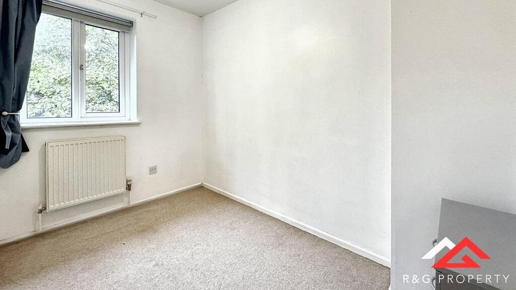 A bright and clean bedroom featuring a large wi...