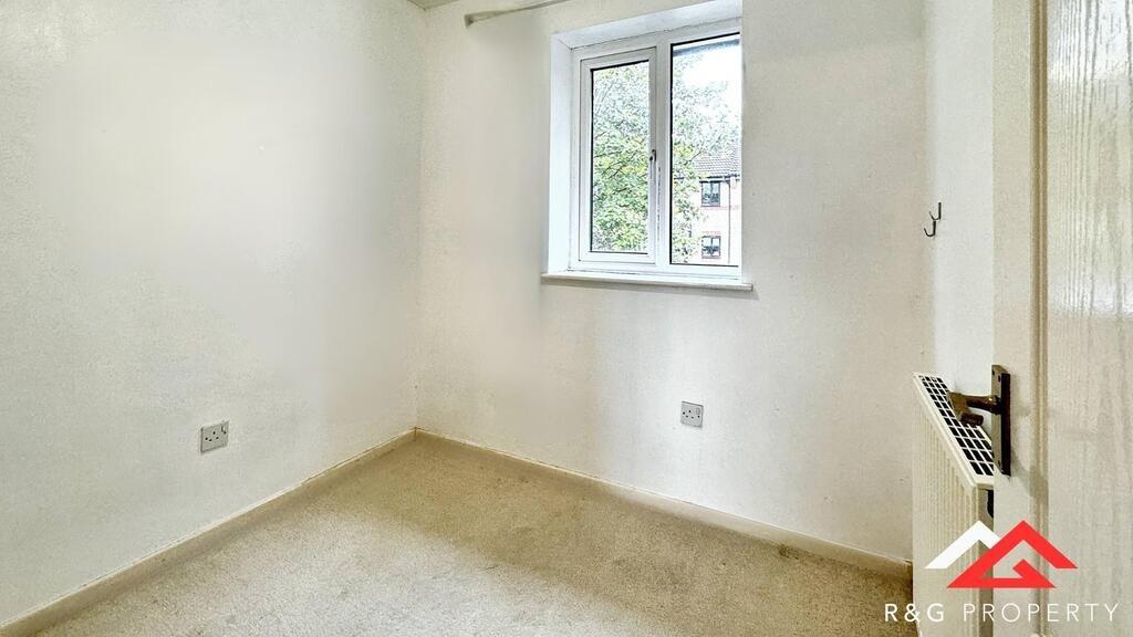 A bright and tidy bedroom with a large window p...