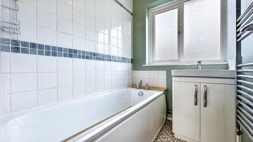 A well-maintained bathroom featuring a bathtub,...