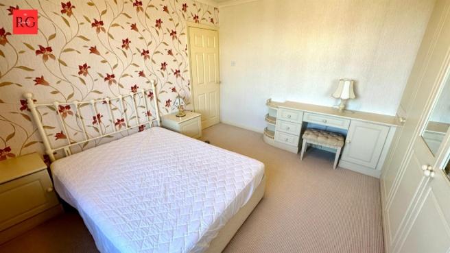 Bright and welcoming double bedroom featuring a...