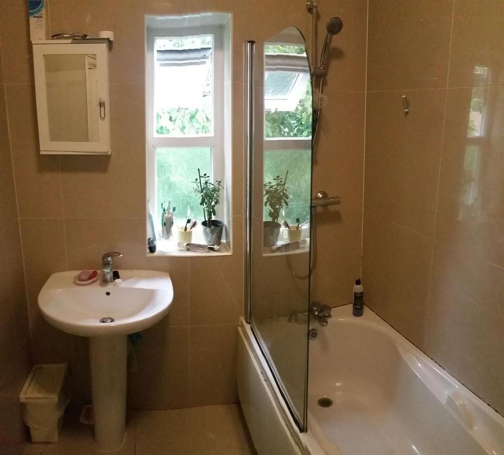 A well-maintained bathroom featuring a bathtub ...
