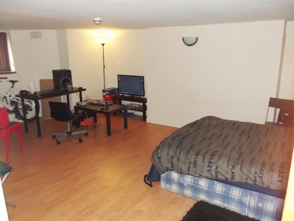 A spacious bedroom with a double bed, ample spa...