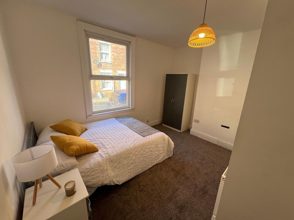 A cozy and well-kept double bedroom featuring a...