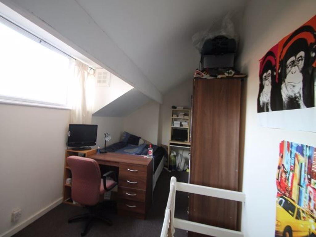 A cozy bedroom featuring a desk and chair near ...