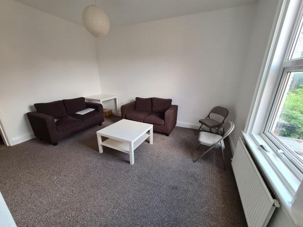 A bright and tidy living room with two comforta...