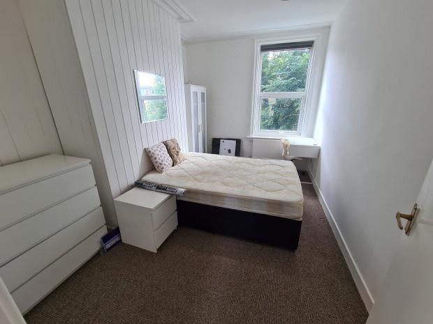 A tidy bedroom featuring a double bed with a sm...