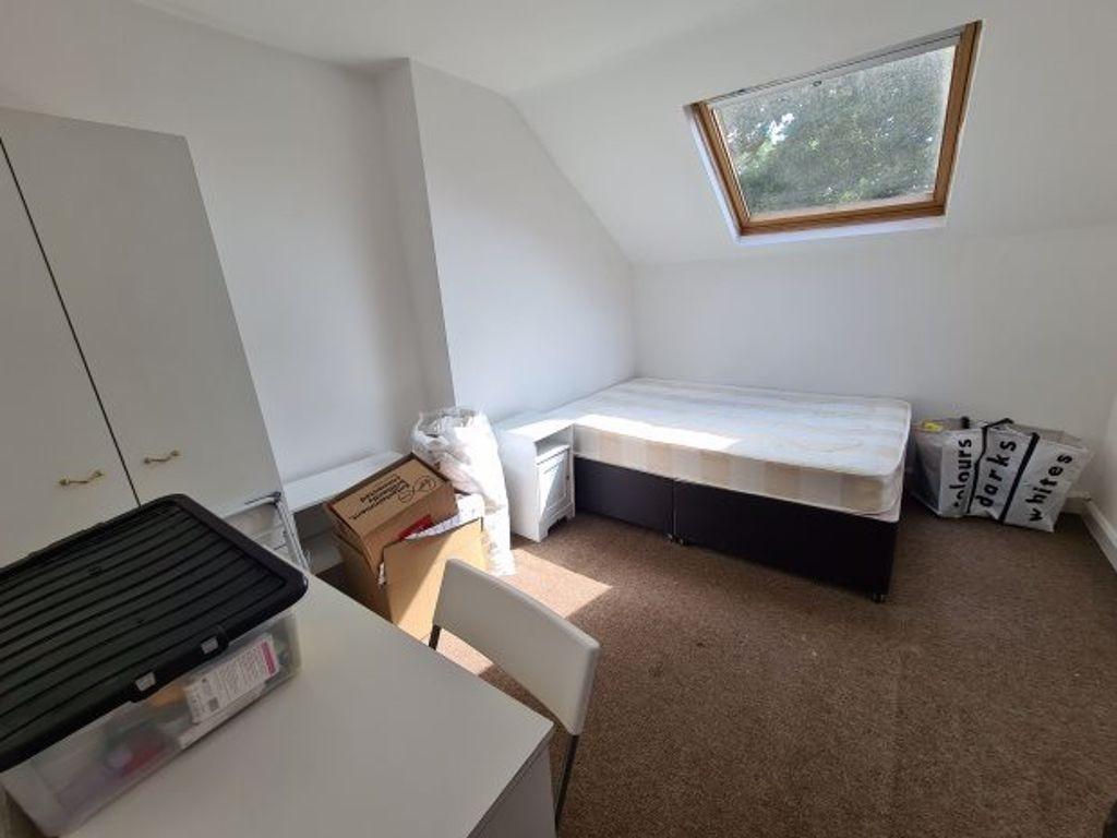 A modest single bedroom with a single bed posit...
