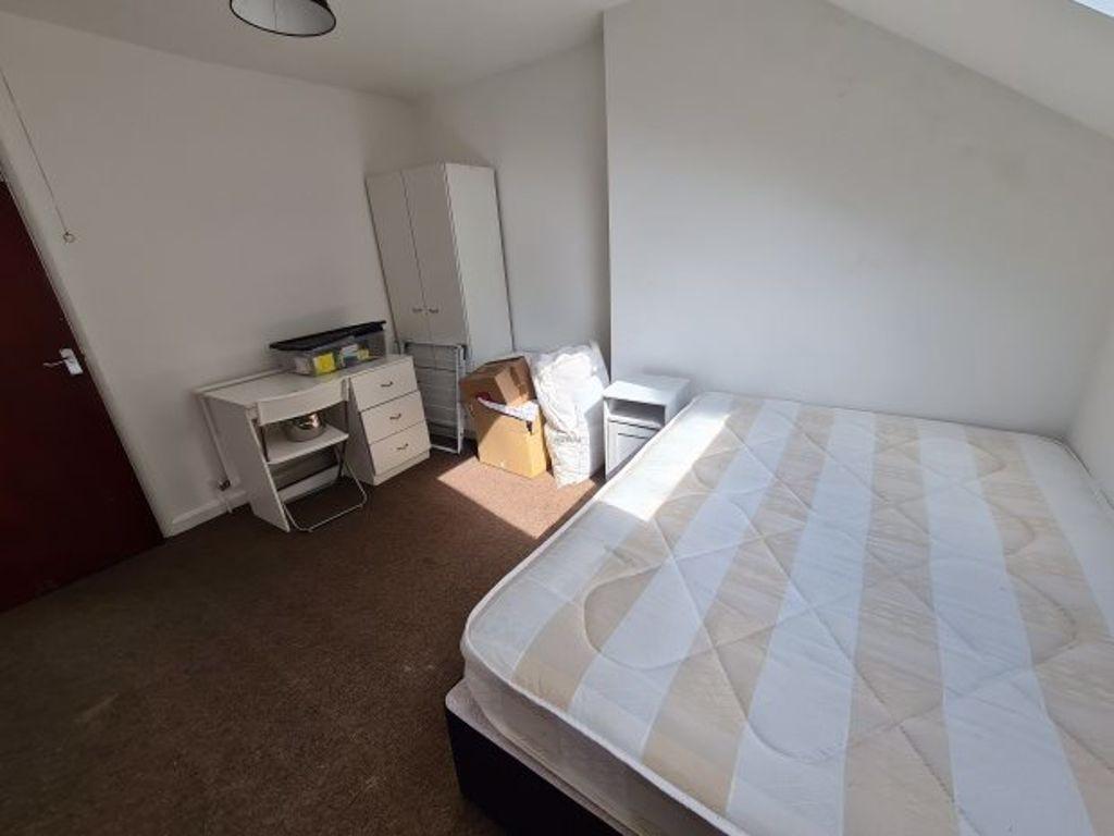 A cozy bedroom featuring a neatly made bed, a s...