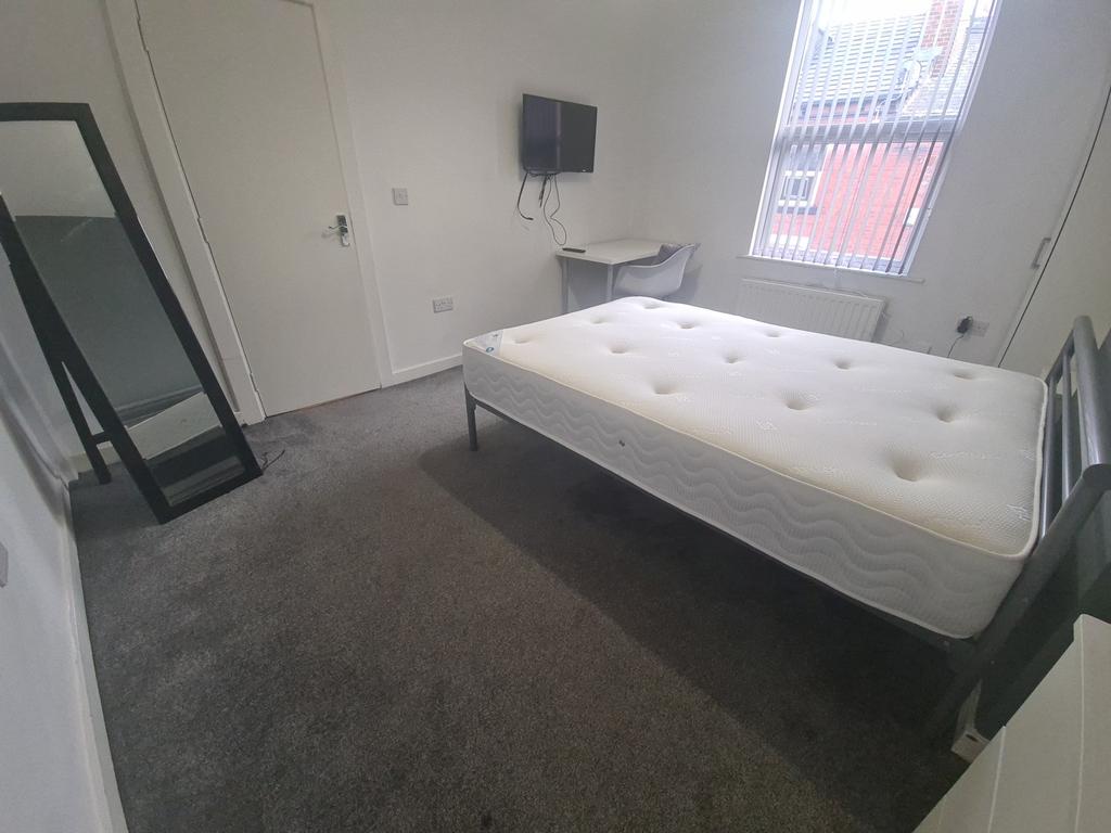 A bright and tidy bedroom featuring a well-made...