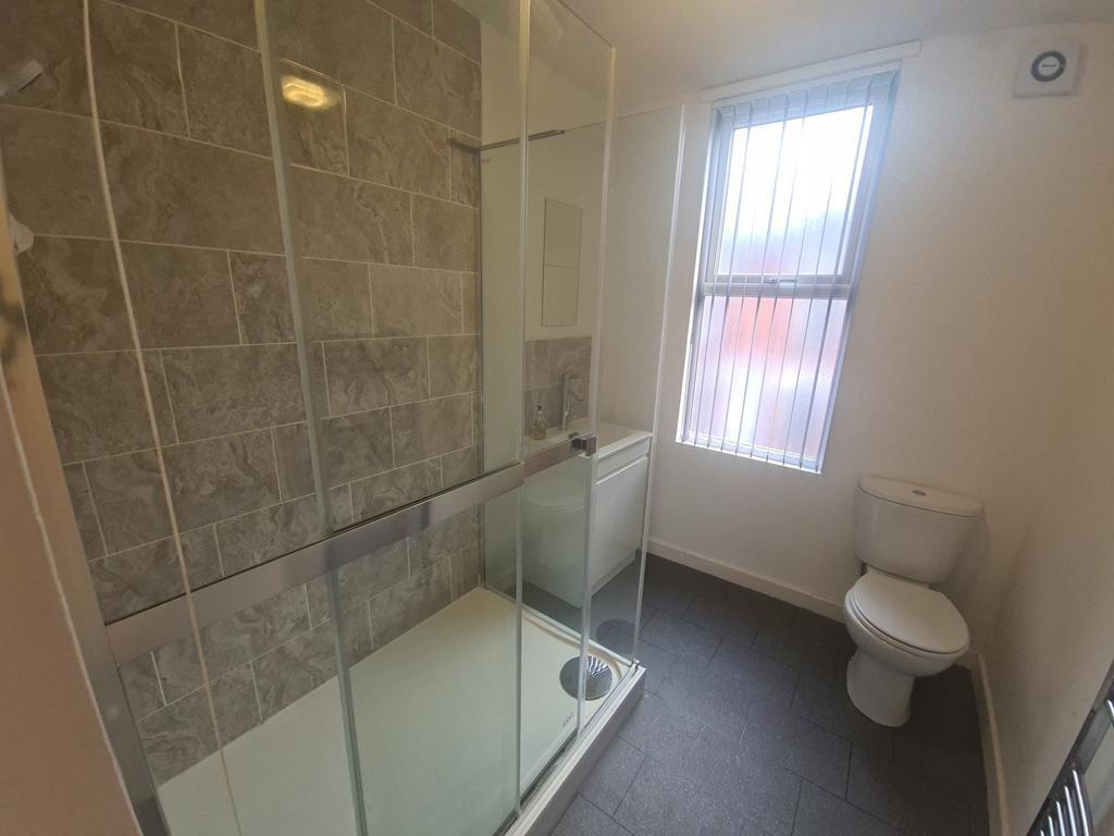 A modern bathroom featuring a spacious shower w...