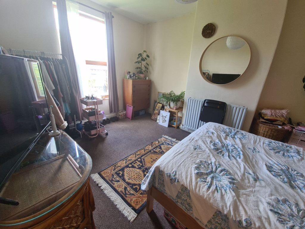 A cozy bedroom featuring a double bed with a ch...