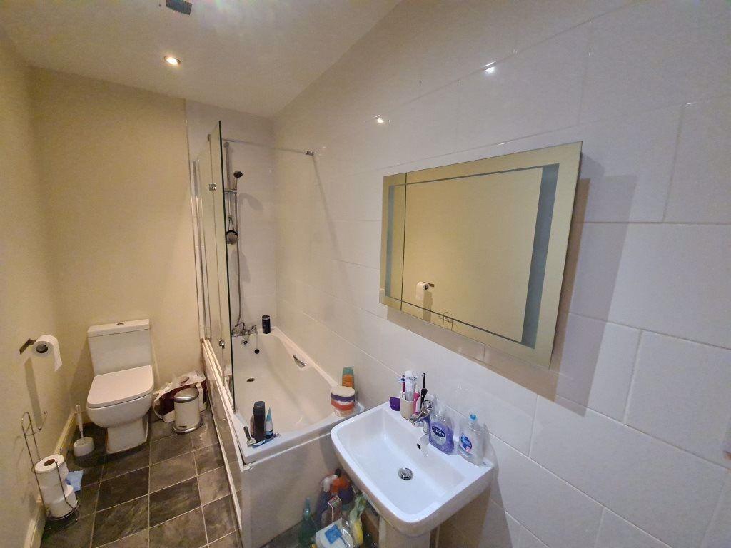 A well-maintained bathroom featuring a bathtub,...