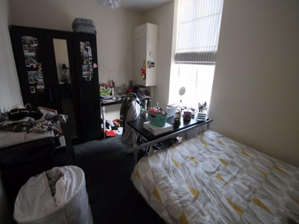 A modest bedroom with a single bed and a window...