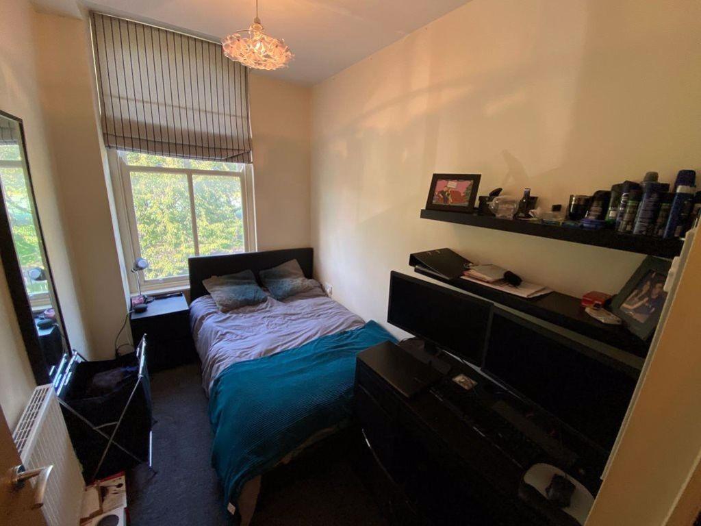 A cozy bedroom featuring a double bed, a desk w...