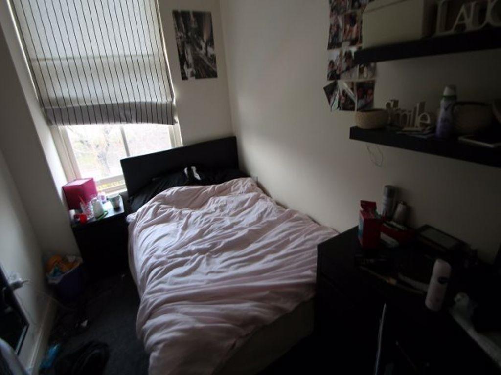 A cozy student bedroom featuring a neatly made ...
