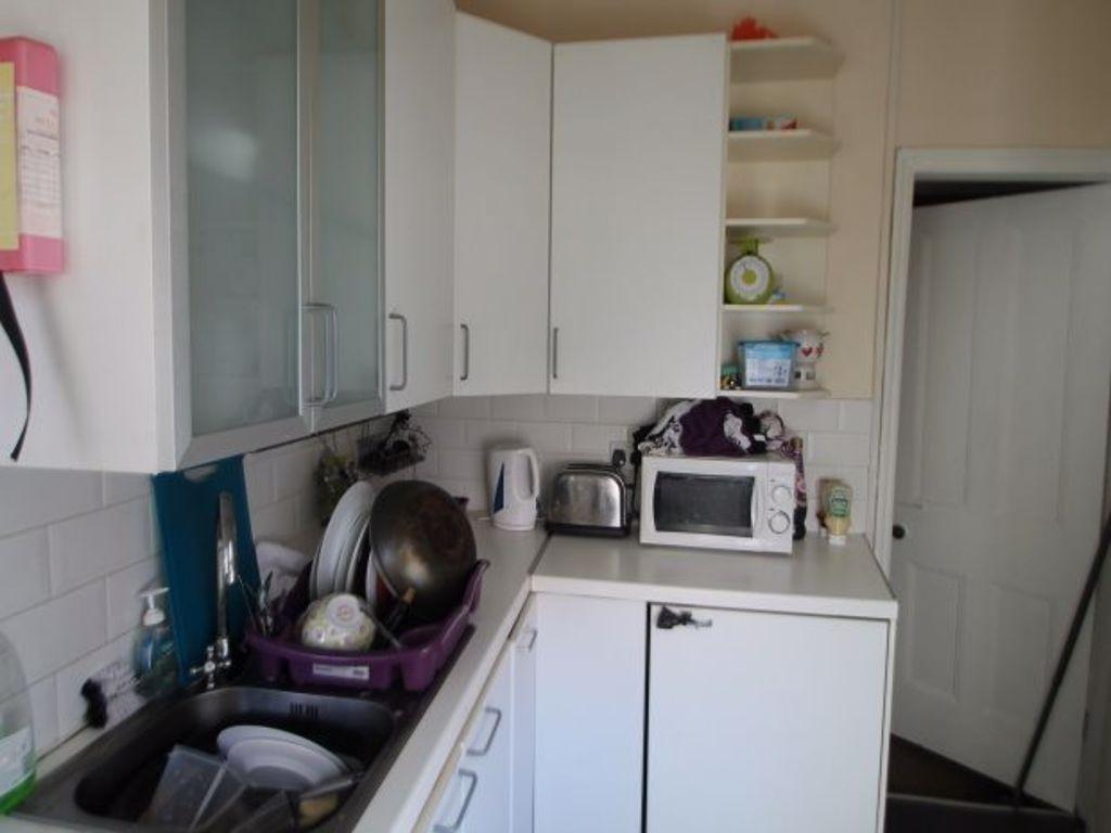 A compact kitchen area with various appliances ...