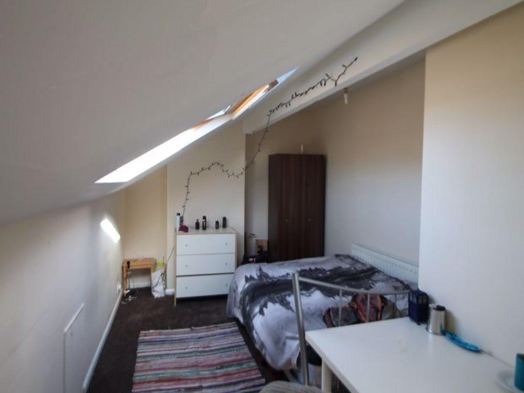 A cozy bedroom with a double bed, a fitted ward...