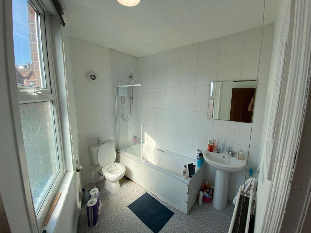 Bright and clean bathroom featuring a bathtub, ...