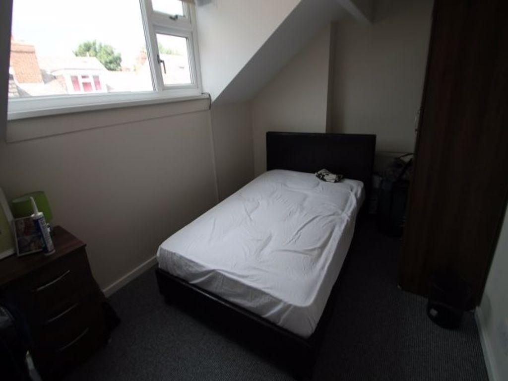 A neatly made master bedroom with a comfortable...