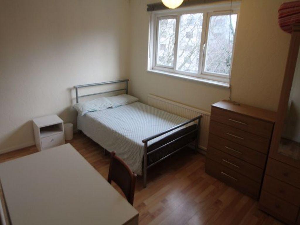 A cozy student bedroom with a clean, simple set...