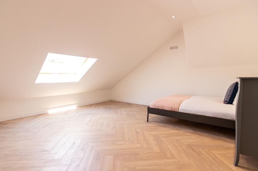 Bright and airy attic-style bedroom featuring a...